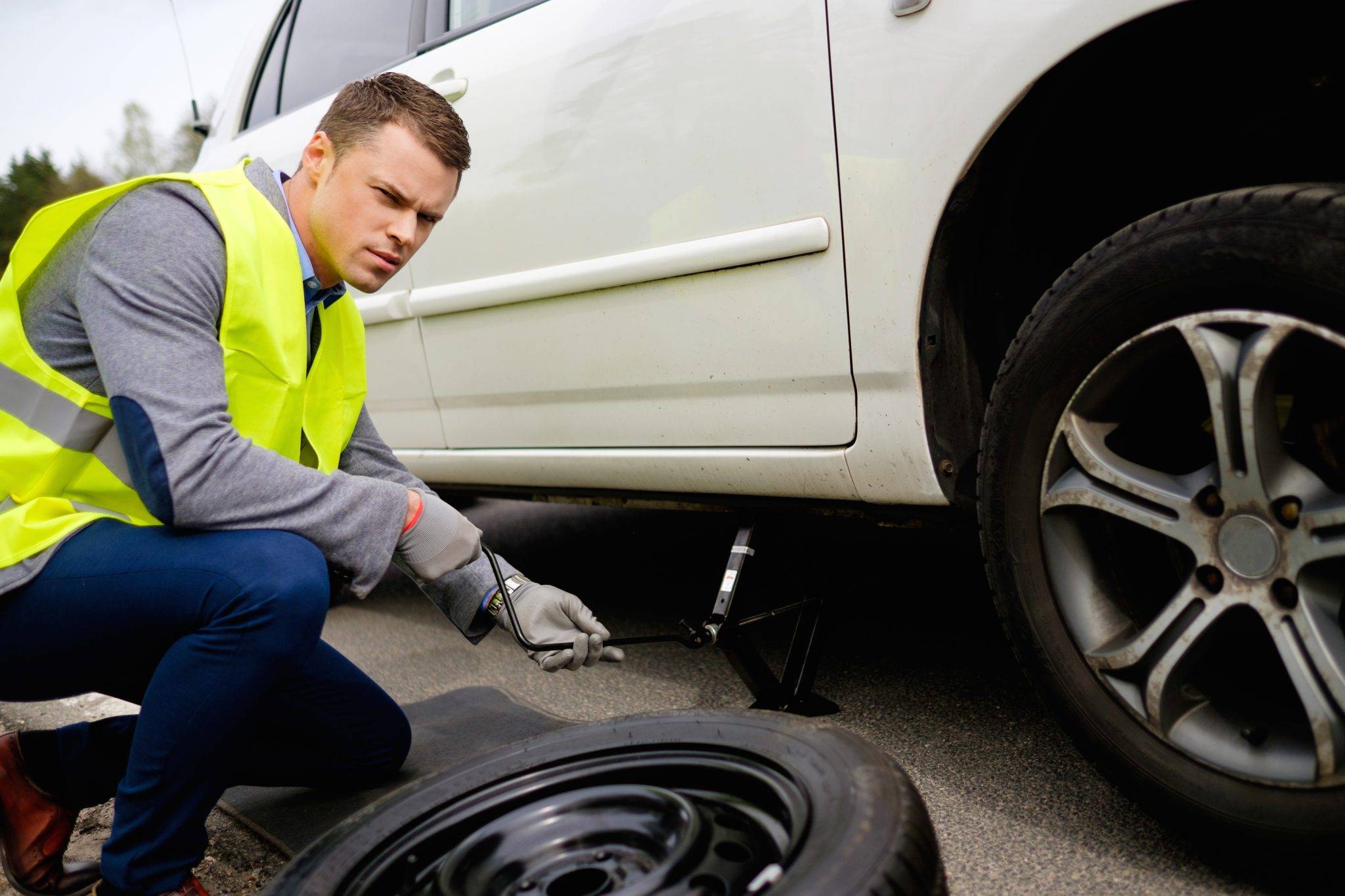 Man Changing Wheel On A Roadside
